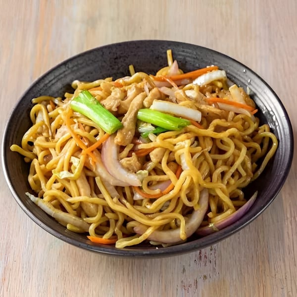 Bo Loong's chicken lo mein, featuring noodles, chicken, onions, carrots, and green onions in a black bowl.