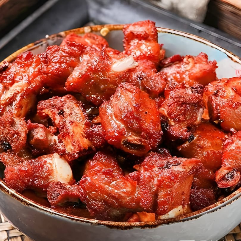 Close-up of Bo Loong's vibrant red Chinese-style sweet and sour pork ribs in a bowl.