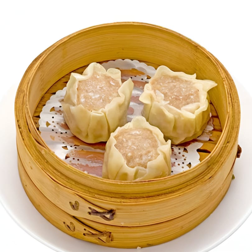 Three steamed Bo Loong Chinese Restaurant shumai dumplings in a bamboo steamer basket on a white plate.