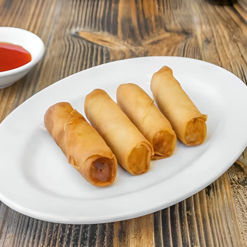 Four crispy Bo Loong Chinese Restaurant egg rolls on a white plate with a side of red dipping sauce.